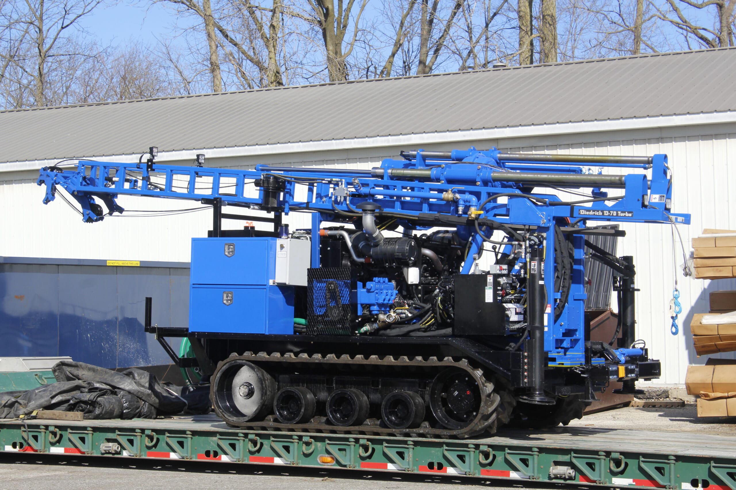 Track-mounted D70 geotechnical drill rig by Diedrich Drill secured on trailer, designed for soil boring, augering, and subsurface exploration projects.